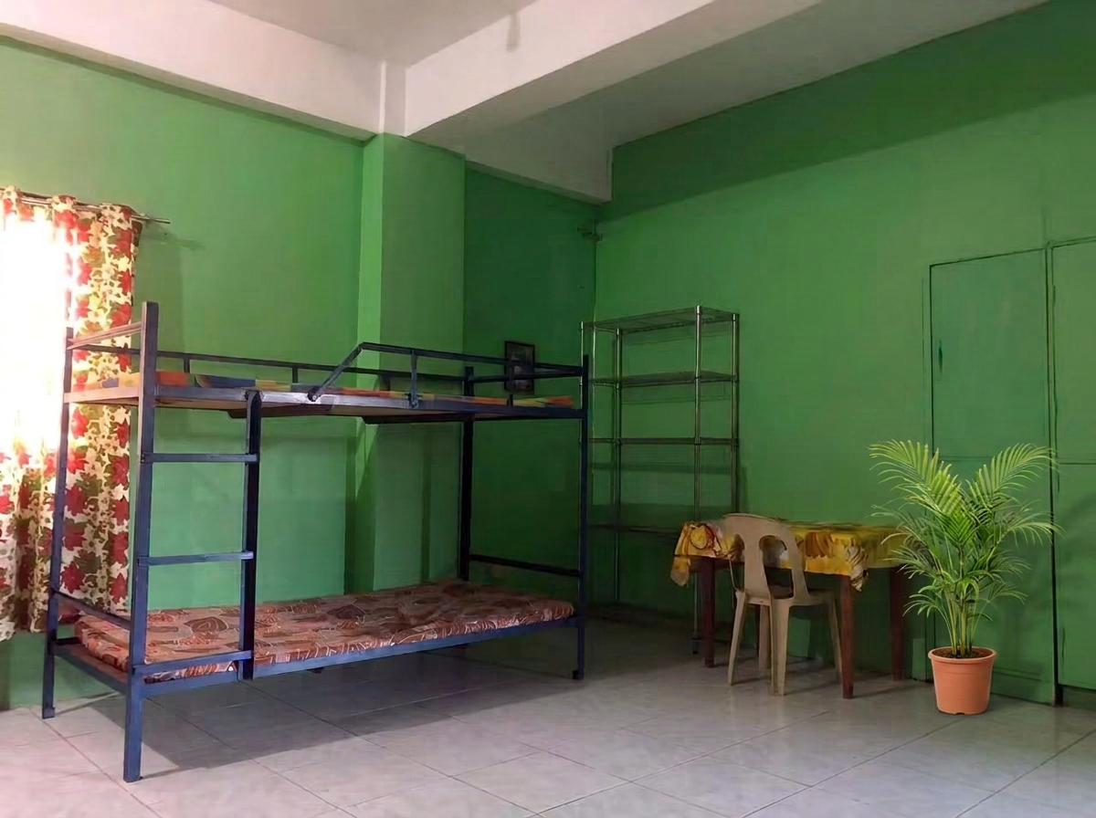 Study table and shelving in a larger room, with a potted palm by the wall.
