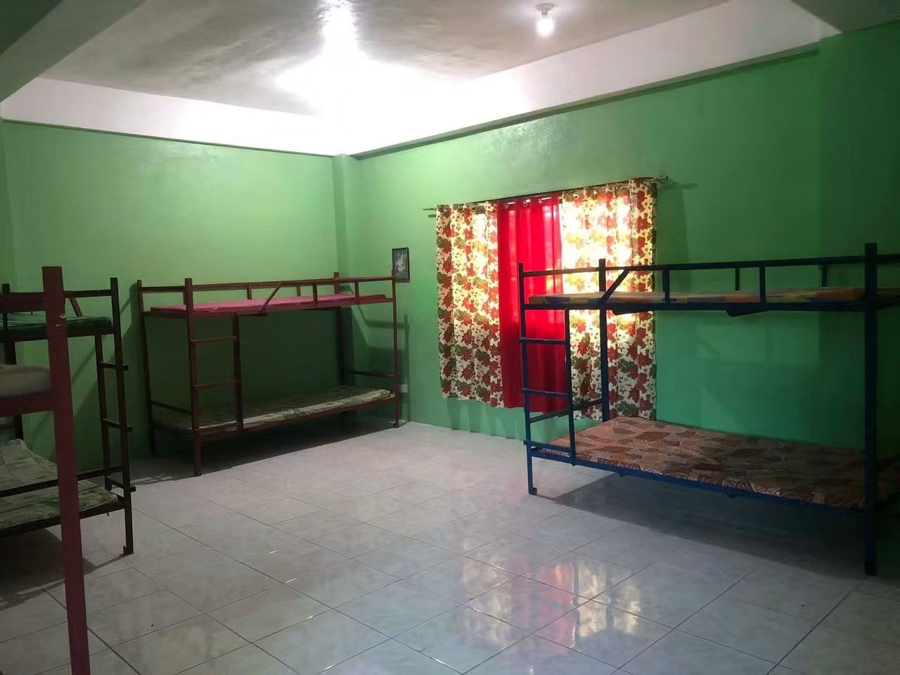 Bed spacer room at GINEL's Dormitory with several bunk beds, a bright window